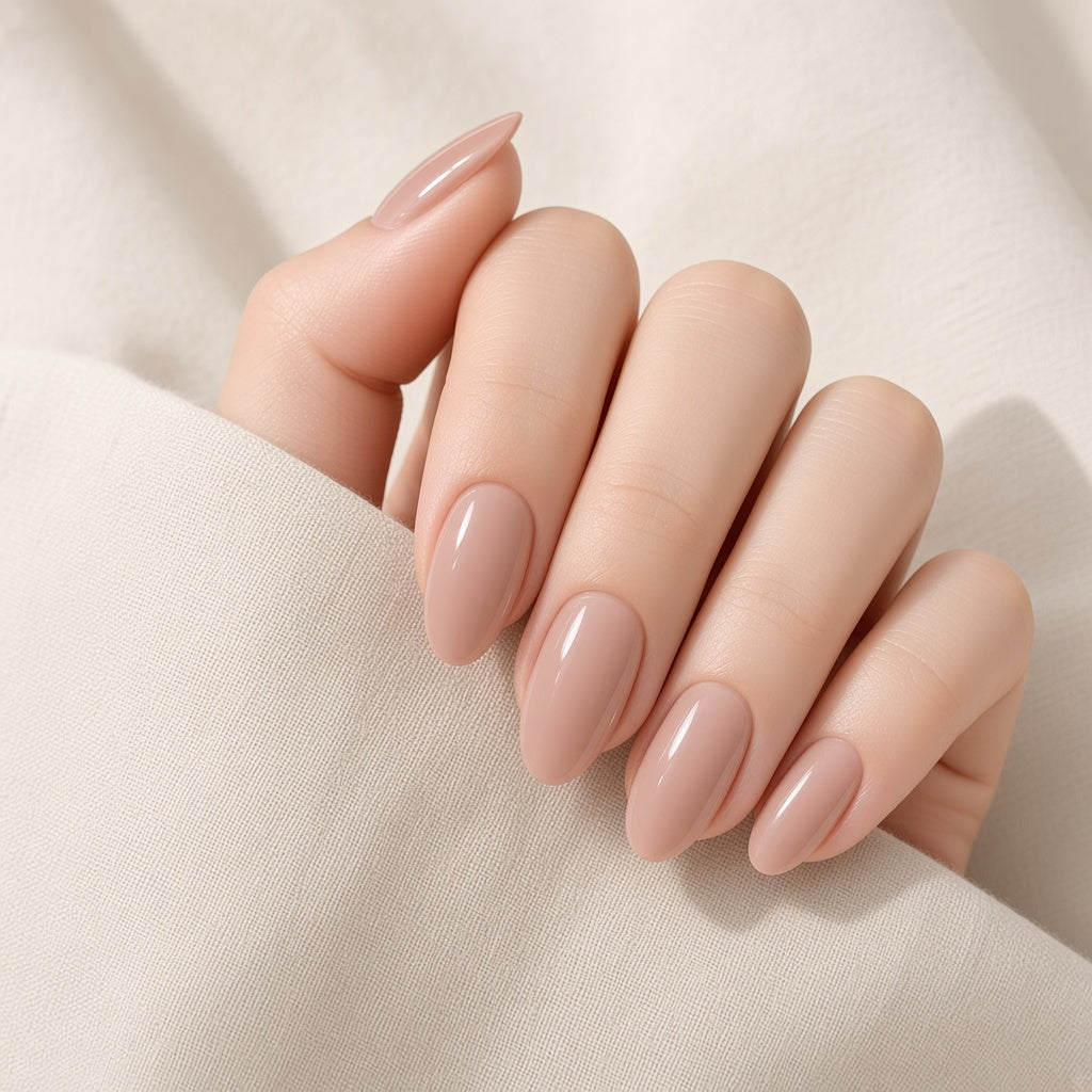 Nude almond press-on nails worn on a hand